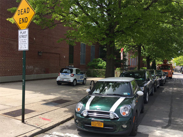 When people can park anywhere with impunity, they will drive more and usurp space where parking is not allowed, like this block that's supposed to be a car-free play street. Photo: Doug Gordon