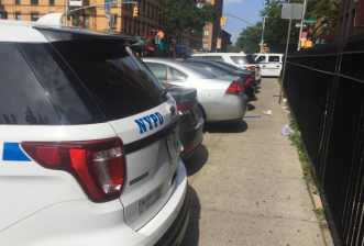 Cars parked on the sidewalk just outside the 88th Precinct back in 2017. Photo: David Meyer
