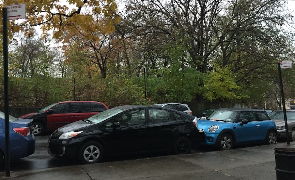 The illegally parked blue Mini has a ticket on the windshield. The illegally parked city-owned Prius, sporting a Human Resources Administration placard on the dashboard, does not.