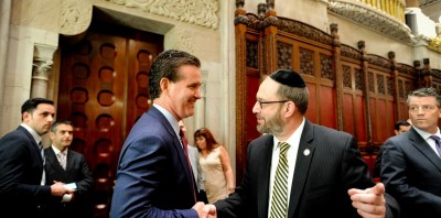 Senate Majority Leader John Flanagan (left, being congratulated by speed camera opponent Simcha Fielder in an unrelated 2015 event) says he will not call his chamber back into session this week to take up speed cameras — and blamed the governor, Democrats and safety advocates. Photo: NY Senate