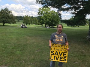 Jane Martin-Lavaud protested outside Senate Majority Leader John Flanagan's golf club as the Republican played golf instead of working to reauthorize the city's speed cameras. Photo by TransAlt.