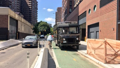 DOT recently added concrete barriers on this stretch of the often-blocked Clinton Street bikeway. They didn't stop the illegal parking. Photo: Jon Orcutt