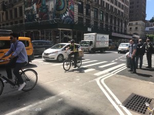 Cyclists must ride right next to heavy traffic at 6th Avenue and 35th Street, where today bike advocates demanded the city think about expanding the bike network ahead of congestion pricing. Photo: Julianne Cuba