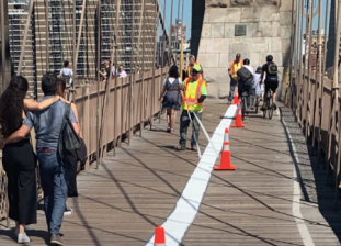 A fresh stripe painted this year on the BrooklynBridge bike/pedestrian path. Photo: Kate Nicholson via Twitter.