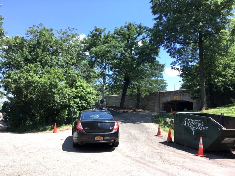 A cyclist going downhill on the Hudson Greenway bike bypass confronts a driver on a Parks Department-only path at 79th Street. The offending dumpster, which apparently had already been moved out of the path, is on the right. Photo: Ken Coughlin