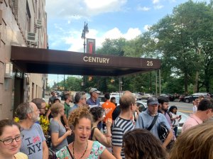 Dozens of people rallied in 2019 outside a building on Central Park West in support of a protected bike lane. Such activism antagonized car-owners on Manhattan CB7, who later moved against street-safety activists on the board. Photo: Jim Burke