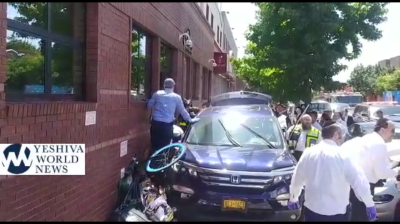 Flatbush Hatzolah workers on the scene of a 2019 crash on Coney Island Avenue. Note the crushed bike against the building wall. Photo: Yeshiva World News