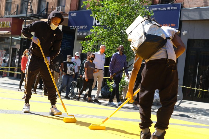 Artists paint a "Black Lives Matter" mural on Fulton Street in Brooklyn, in front of Restoration Plaza. Photo: NYC Mayor's Office