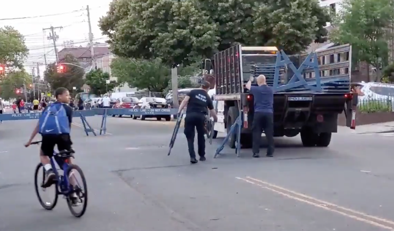 Police workers remove barricades so that car drivers once again have full access to the open street portion of Rhinelander Avenue at the expense of COVID-19 open space protocols. Photo: Michael Kaess