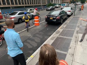 Council Member Steve Levin (disembodied arm at right) gestures towards a family that is being forced into danger by an illegally parked, FDNY-placard-bearing car. Photo: Gersh Kuntzman