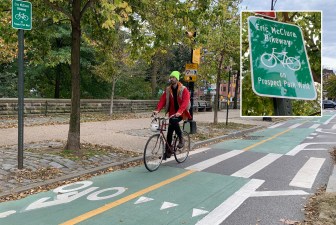 A cyclist enjoys the Prospect Park West bike lane — not noticing its subtle renaming (inset). Photo: Gersh Kuntzman