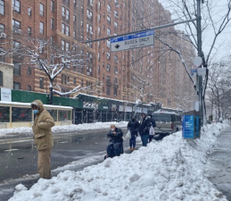 Bus riders are forced into the street because of snow pileups. Photo: Christine Berthet