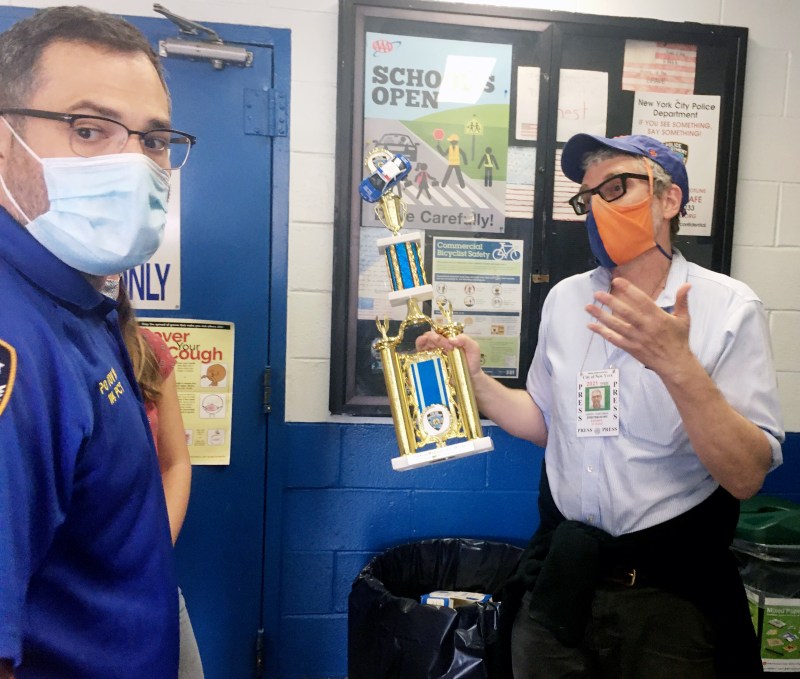 Streetsblog Editor Gersh Kuntzman makes the case to Community Affairs Officer Gabriel Tovar to accept the Parking Madness trophy. Photo: Eve Kessler