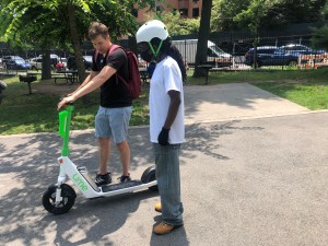 Lime's Russell Murphy teaching a Bronx resident how to ride an e-scooter. Photo: Fiifi Frimpong