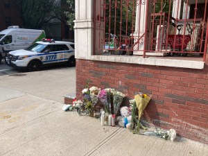 An NYPD squad car sits in the bike lane across from a memorial for a 3-month-old killed by a reckless driver at the corner of Vanderbilt and Gates avenues in Brooklyn. Photo: Julianne Cuba