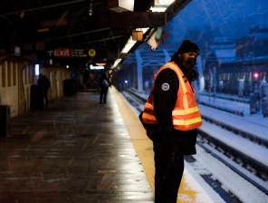 A worker surveys the snow on an elevated subway platform. Photo: MTA