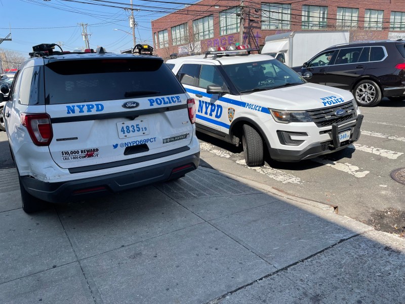 Police SUVs block the curb and crosswalk outside the 69th Precinct.
