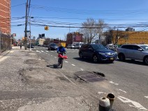 A delivery cyclist riding on the crumbling roads in Blissville, Queens. Photo: Julianne Cuba