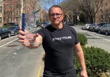 Clarence Eckerson Jr. on the 34th Avenue open street with his award from the United Freakin' Nations.
