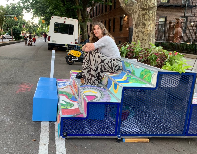 She stoops to conquer: A woman hangs out on the larger of the new 34th Avenue Open Street stoops. Photo: Gersh Kuntzman