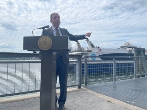 City Comptroller Bd lander gestures towards a ferry boat in lower Manhattan. Photo: Dave Colon