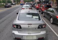 A line of unticketed cars parking in the bike lane in Upper Manhattan.
