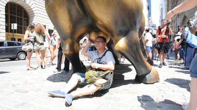 Tourists love the Charging Bull statue at the top of Bowling Green. They don't love the cars. Photo: George Goss