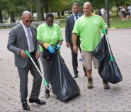 Announcing a Sanitation Department compost recycling inititative,Mayor Adams tries out trash collection with a worker in Flushing Meadow Park. Photo: Mayor's Office