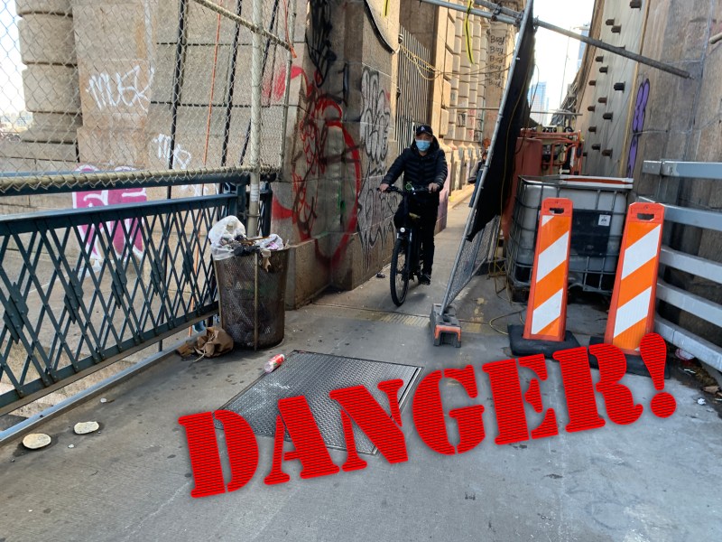 Coming through! Cyclists navigate the tight space left as stored construction block much of the bike path on the Manhattan Bridge. Photo: Gersh Kuntzman