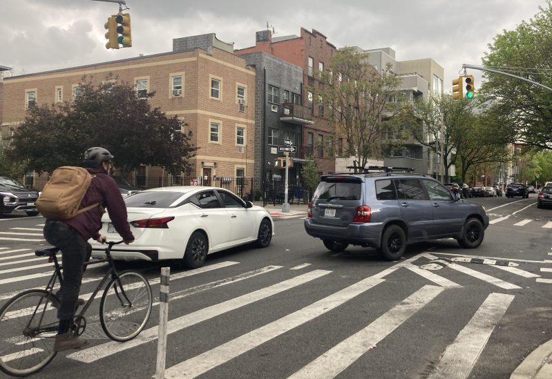 A cyclist crosses the intersection where Adam Uster was killed on Monday. Photo: Julianne Cuba