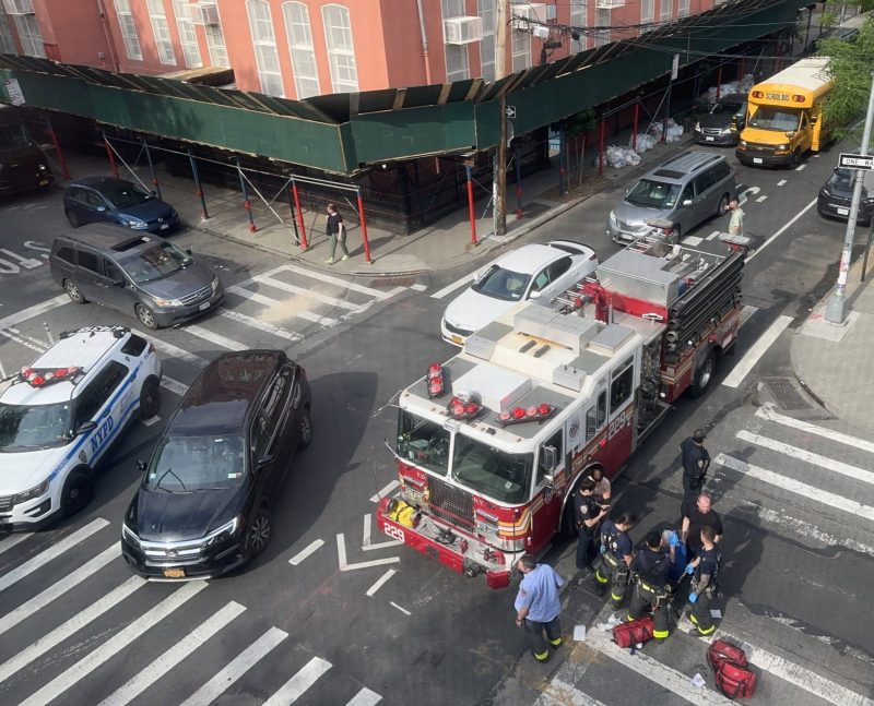Firefighters help cyclist Teddy Orzechowski after an SUV driver hit him at Driggs Avenue and Monitor Street on May 12. Photo: Noel Hidalgo